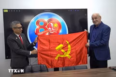 越南驻以色列大使李德忠向以色列共产党政治局委员、哈达什阵线主席伊萨姆·马库尔赠送党旗。图自越通社