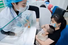 医务人员为患儿采集样本进行流感检测。图自越通社