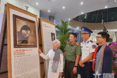 昆岛前政治犯黎秀锦观看年轻时期的肖像画。图自qdnd.vn
