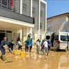 志愿力量在太原省卫生厅办公驻地清理洪水过后的淤泥。图自越通社