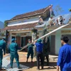 Lực lượng xung kích xã Tây Hồ (Đà Nẵng) giúp dân sửa chữa nhà bị tốc mái. Nguồn baochinhphu.vn 岘港市西湖乡突击队帮助居民修复被掀翻屋顶的房屋。图自baochinhphu.vn