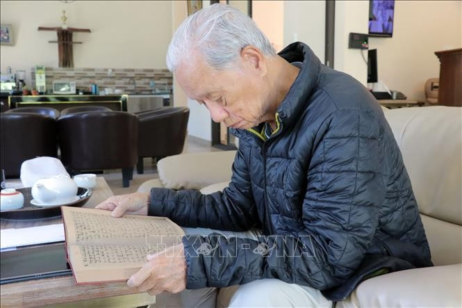 老战地记者严士泰翻阅那本遗失近60年的日记，仿佛回到了烽火连天的岁月。图自越通社