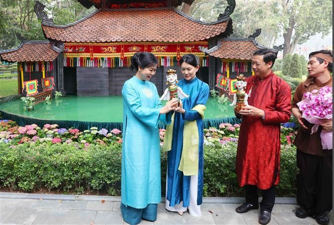 越共中央总书记夫人与新加坡总理夫人共赏水上木偶戏。图自越通社