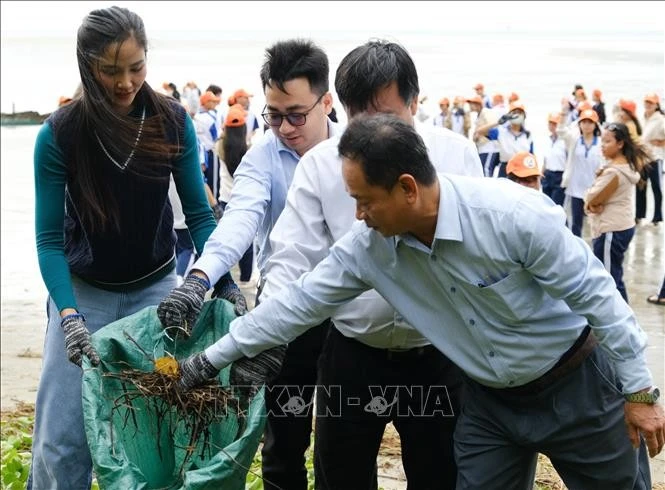 代表们参与清理垃圾、净化海洋环境活动。图自越通社