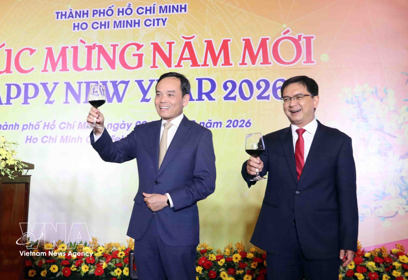 越共中央政治局委员、胡志明市市委书记陈流光（左）与各位来宾举杯共庆新年。图自越通社