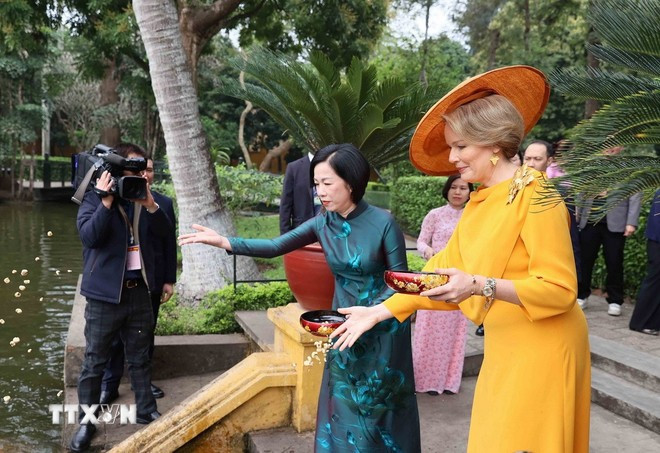 玛蒂尔德王后同阮氏明月夫人在胡伯伯鱼塘给鱼喂食。图自越通社