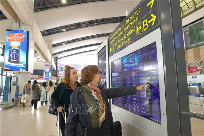 国际旅客在内排机场查看信息。图自越通社