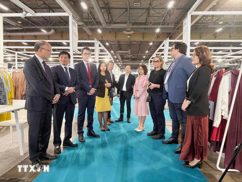 越南驻法国大使丁全胜与参加展览的越南企业代表交流。图自越通社