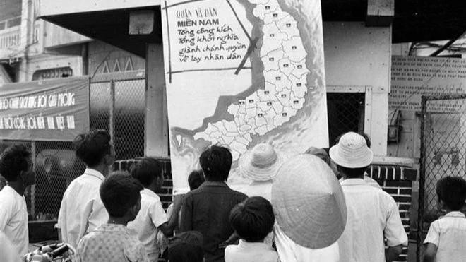 刚刚解放的平顺省潘切市人民在信息室观看战争地图上的胜利消息(1975年4月)。图自越通社