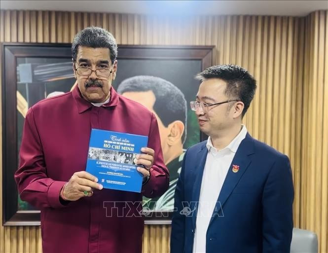 马杜罗总统接收由阮祥林赠送的《世界人民对胡志明主席的感情》（西班牙语版）书籍。图自越通社