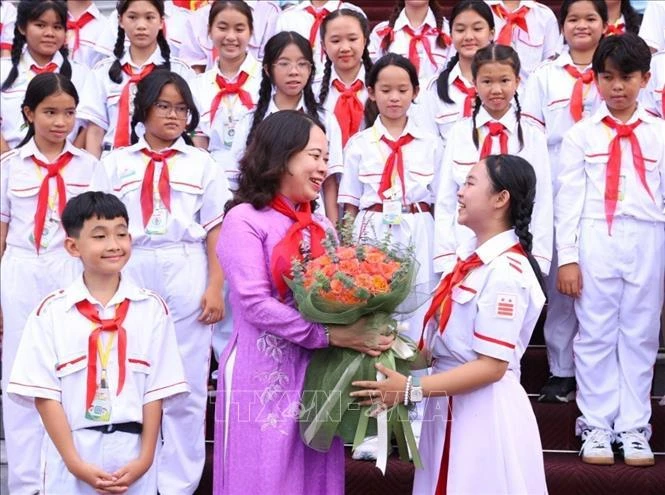 胡志明市少年向国家副主席武氏映春送花。图自越通社