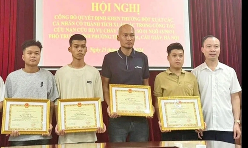 四名青年因勇敢救助火灾中受困人员而获得纸桥郡人民委员会的奖状。图自越通社