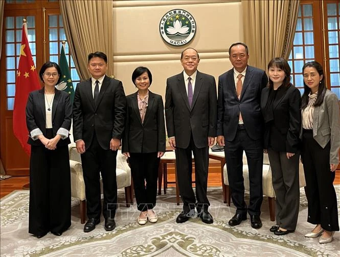 越南驻香港和澳门总领事黎德幸（左）与中国澳门特别行政区行政长官贺一诚和代表们合影。图自越通社