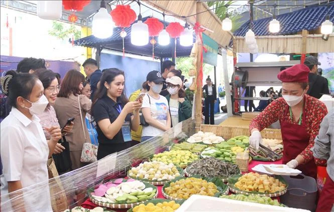 南部民间饼展位吸引重大游客驻足体验。图自越通社