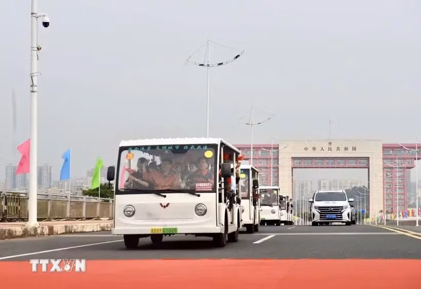 载着出境游客的电动汽车在北仑二桥通行。图自越通社