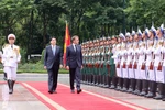 国家主席梁强和法国总统埃马纽埃尔·马克龙检阅仪仗队。图自越通社