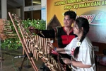 越南留学生体验敲击特龙琴（T'rung）。图自越通社