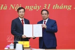 范明政总理向河内国家大学新任校长裴世维颁发任命决定。图自越通社