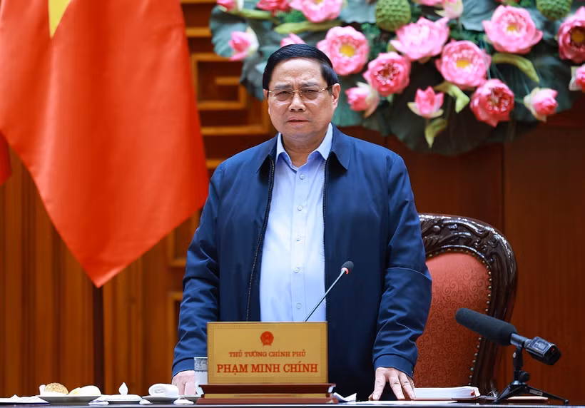 越南政府总理范明政在政府驻地就为洪涝灾后民众修建、修缮房屋计划"光中战役"实施情况，与广治省委常委会召开工作会议。图自越通社