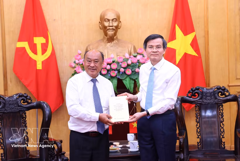 越共中央政治局委员、胡志明国家政治学院院长段明训副教授向老挝人民革命党中央委员会委员、党委书记、老挝经济和社会科学院（LASES）院长里伯·里布阿帕赠书。图自越通社