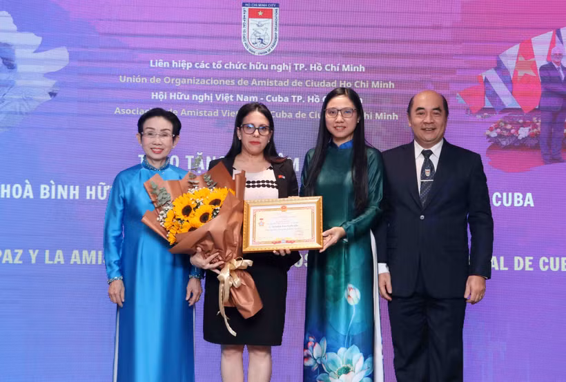 胡志明市友好组织联合会主席何清向古巴驻胡志明市总领事阿里亚德娜·费奥·拉布拉达颁授“致力于各民族和平友谊”的纪念章。图自越通社