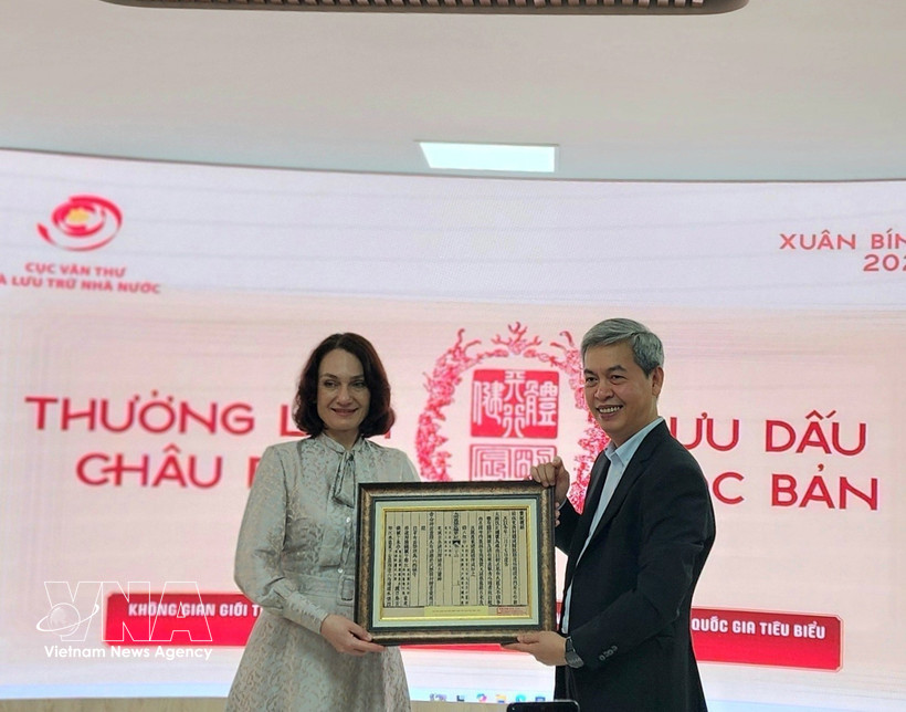 越南国家文书与档案局局长邓青松向俄罗斯驻越大使夫人埃琳娜·贝兹德特科赠送一幅越南国号的木刻版画。图自越通社