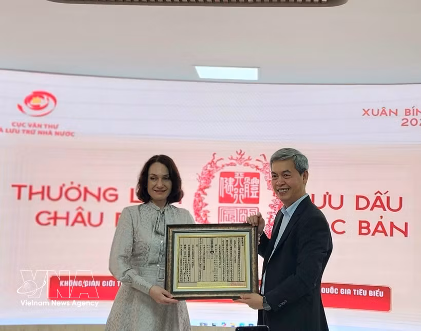 越南国家文书与档案局局长邓青松向俄罗斯驻越大使夫人埃琳娜·贝兹德特科赠送一幅越南国号的木刻版画。图自越通社