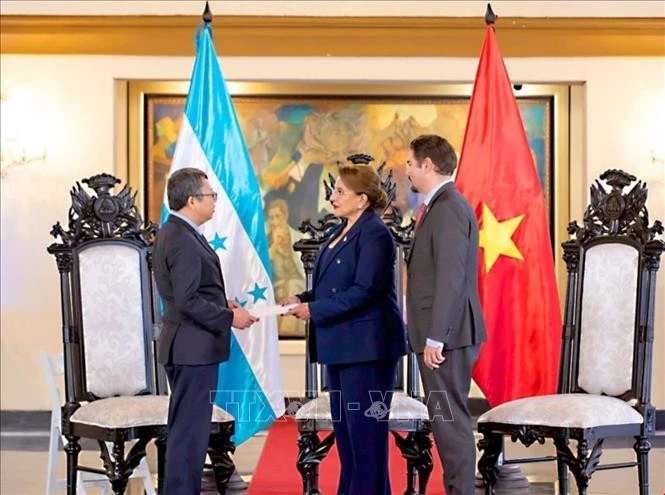越南驻墨西哥兼驻洪都拉斯大使阮文海向洪都拉斯总统伊丽丝·希奥玛拉·卡斯特罗·萨缅托（Xiomara Castro）递交越南国家主席梁强的委任书。图自越通社
