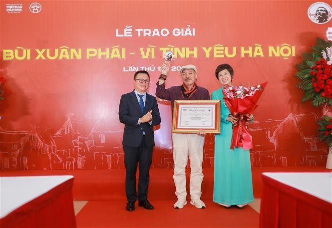 越南记者协会主席、《人民报》总编辑黎国明与越通社社长武越庄为陈进颁授“热爱河内”大奖。图自越通社