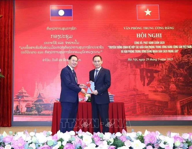 越共中央书记处书记、中央办公厅主任黎淮忠向老挝人民革命党中央书记处书记、中央办公厅主任通沙立·蒙诺梅赠送《越共中央办公厅和老挝人民革命党中央办公厅合作关系传统》一书。图自越通社