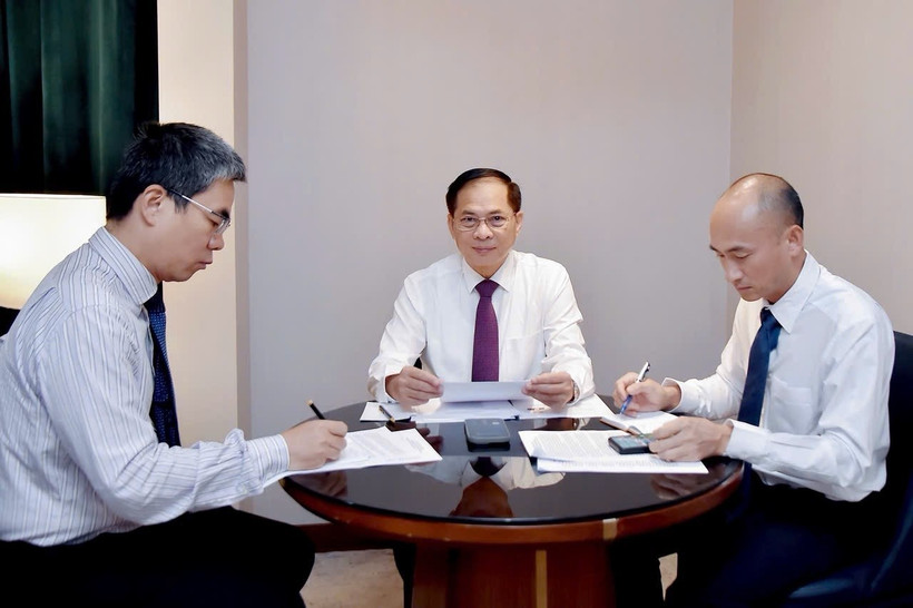越南政府副总理兼外交部长裴青山（左二）与韩国外长赵显通电话。图自越通社