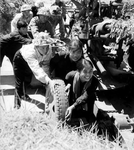 从1955年至1975年，越南共产党在建国卫国的伟大事业中，领导全国取得了巨大胜利，北方致力于社会主义建设，南方则展开了争取国家统一的斗争。图为：1965年，广平省东富乡的男女青年帮助部队将炮兵拉入阵地。图自 越通社