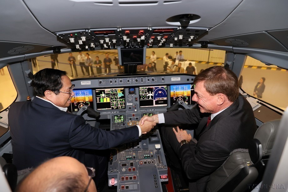 2023年，越南政府总理范明政在巴西航空工业公司（Embraer）董事长兼首席执行官弗朗西斯科·戈麦斯·内托的陪同下，参观该公司飞机展区及其现代化生产设施。图自 越通社