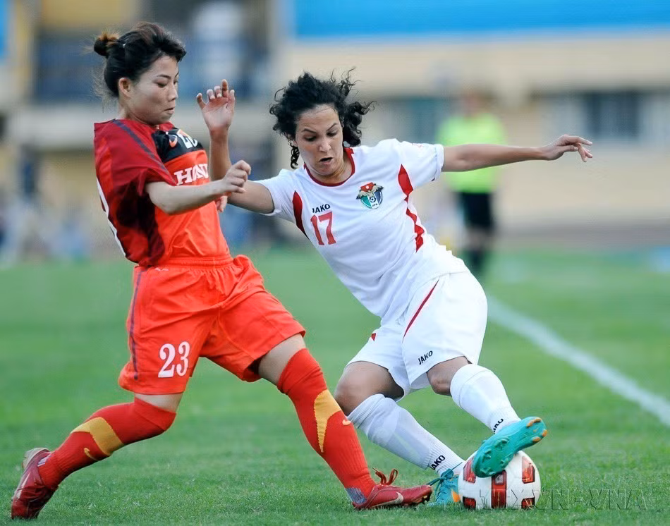 越南女足（红衣）与约旦女足（白衣）在河内行待（Hàng Đẫy）进行国际女足友谊赛（2013年4月26日）。图自 越通社