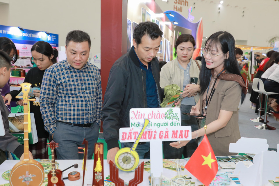 众多游客在金瓯省展位兴致勃勃地领取旅游报名单和礼品券。图自 越通社