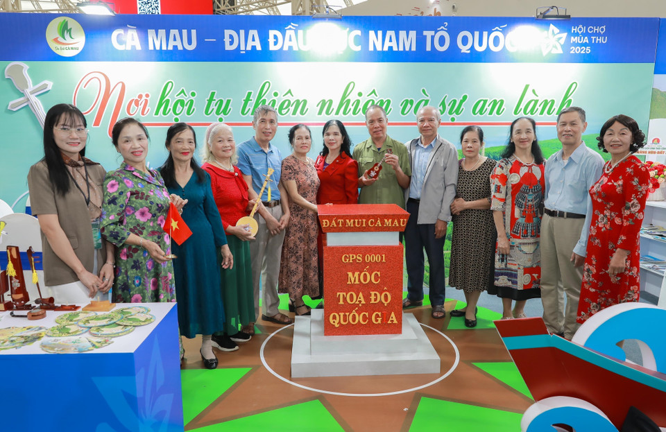 众多游客在金瓯省展位处的越南最南端地标前打卡留念。图自 越通社