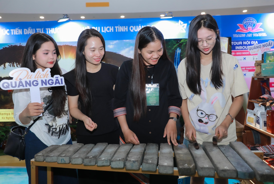 游客在工作人员指导下，于广义省展位体验石琴等传统乐器。图自 月通社