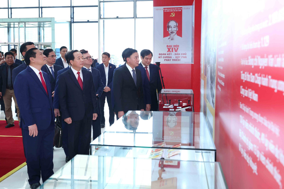 越共中央书记处常务书记陈锦秀与党和国家领导同志一同参观由越通社举办的《在党旗帜下，国家迈入新纪元》图片展。图自 越通社