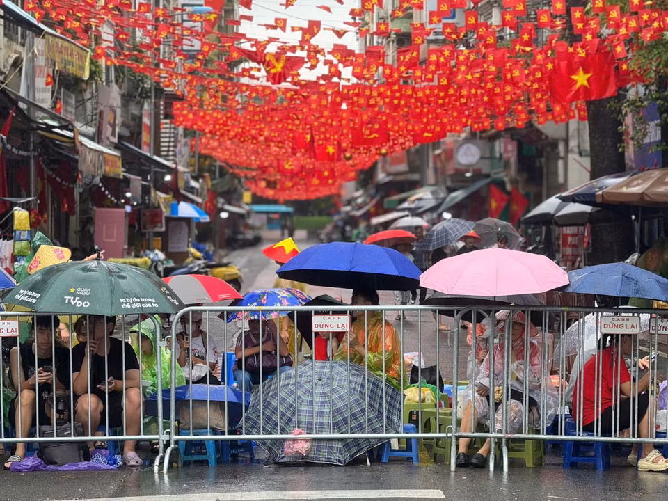 尽管大雨滂沱，仍有数千名市民涌向街头，耐心守候，欢迎参与国庆80周年庆典阅兵游行的各方阵。图自越通社