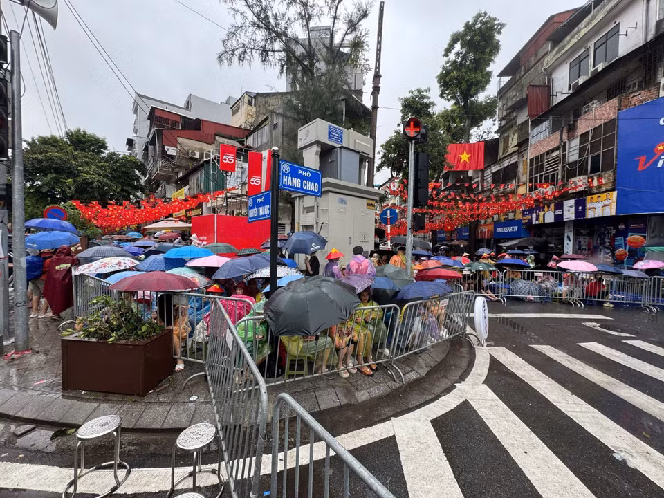 尽管大雨滂沱，仍有数千名市民涌向街头，耐心守候，欢迎参与国庆80周年庆典阅兵游行的各方阵。图自越通社