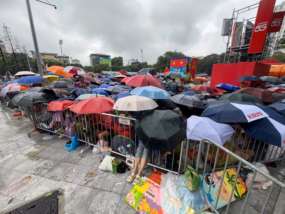 在大雨中，首都河内的市民无惧恶劣天气，耐心守候，只为即将登场的武装力量方阵加油助威。图自越通社。