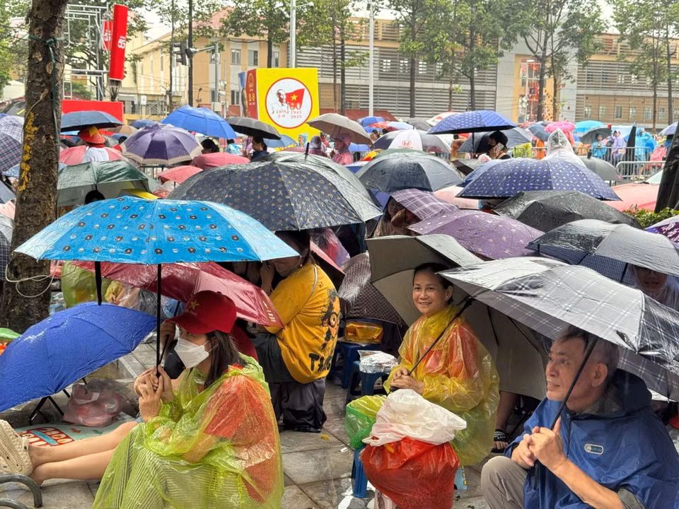 在大雨中，首都河内的市民无惧恶劣天气，耐心守候，只为即将登场的武装力量方阵加油助威。图自越通社。