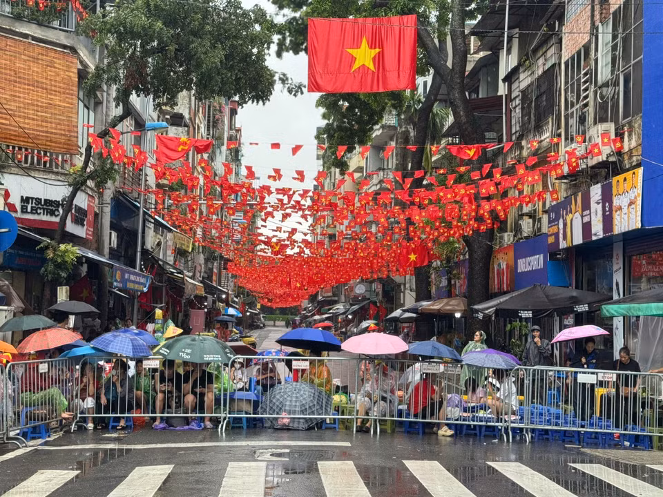 尽管大雨滂沱，仍有数千名市民涌向街头，耐心守候，欢迎参与国庆80周年庆典阅兵游行的各方阵。图自越通社