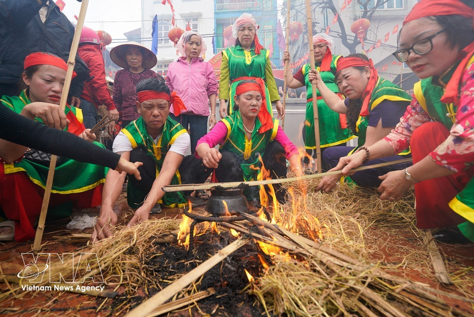 煮饭比赛在氏锦村村亭院内热烈展开。图自 越通社