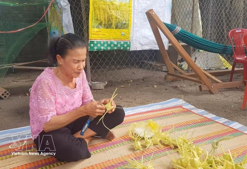 艺人娘芳细致编织每一个石榴粽外壳，展现出高棉族女性娴熟精湛的手工技艺。图自 越通社