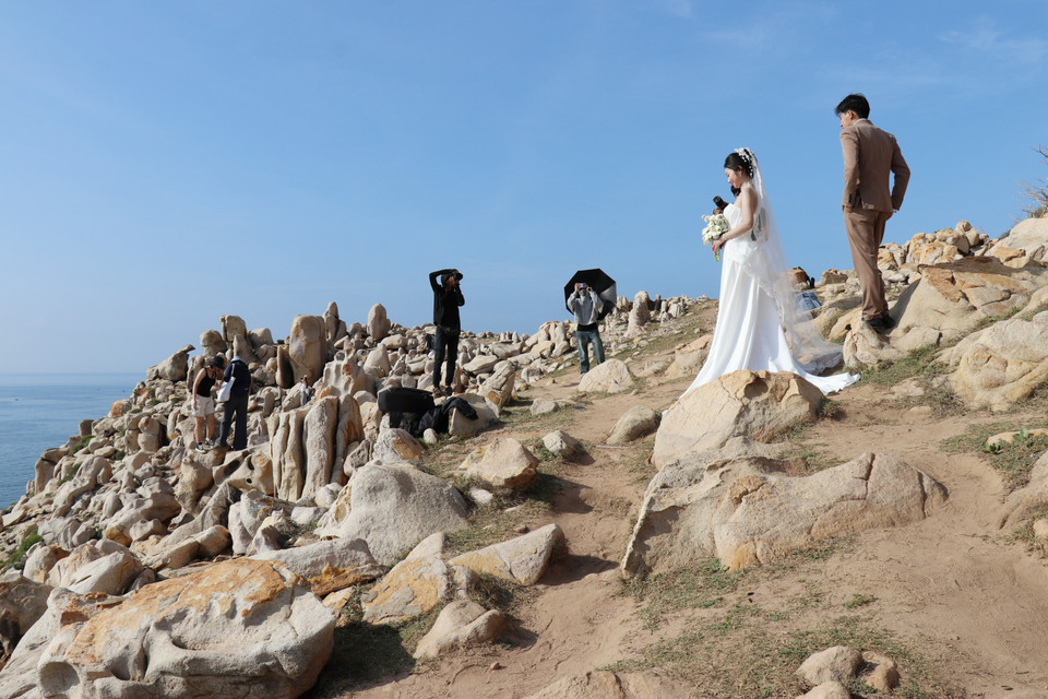 游客在宁顺省宁海县永海乡的主山国家公园岩石公园内拍照留影，记录下这片奇岩美景带来的震撼与感动。图自 越通社