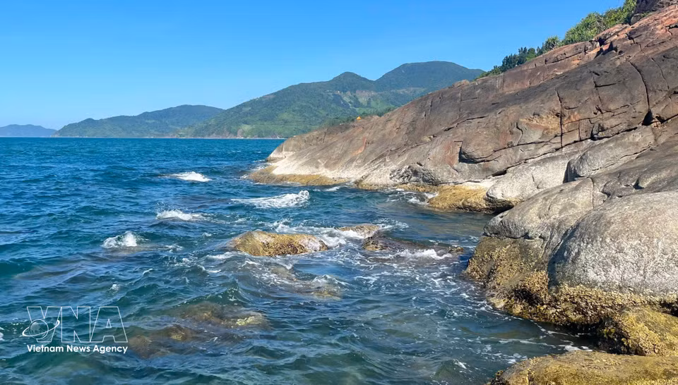 海云山脚下，一块块深灰色岩石散落其间，宛如大自然镶嵌在陵姑湾碧海之间的粗犷拼图，与柔美的海景形成鲜明对比。图自 越通社