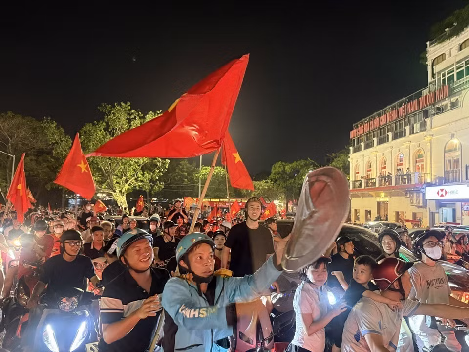越南首都市民手举祖国国旗，在河内各条街道上游行，热烈欢庆胜利。图自 越通社