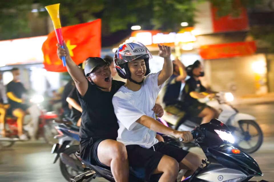 首都市民手举祖国国旗，齐聚东经义塾广场一带，兴高采烈地庆祝胜利。图自 越通社