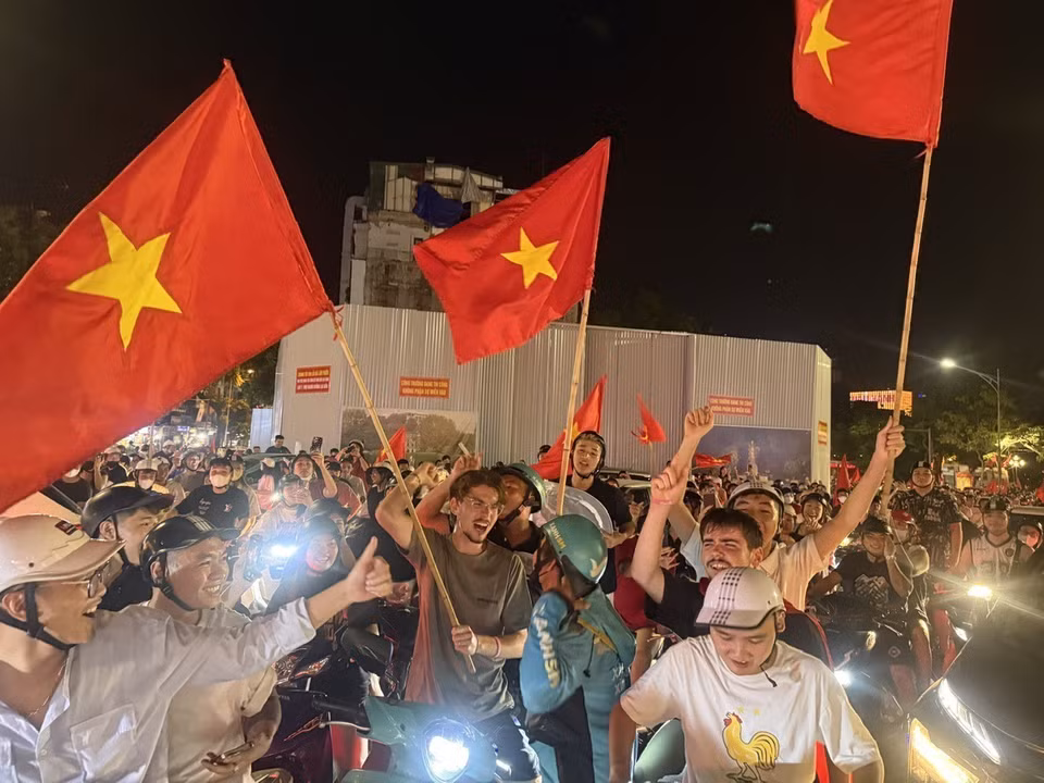 越南首都市民手举祖国国旗，在河内各条街道上游行，热烈欢庆胜利。图自 越通社